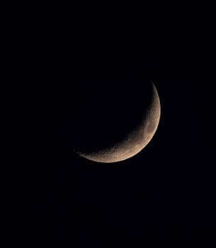 A crescent moon prominently displayed against a dark night sky, ideal for astronomy enthusiasts.