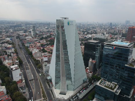 A stunning aerial view of the Reforma Tower and Mexico City skyline, showcasing modern architecture in a bustling urban landscape.