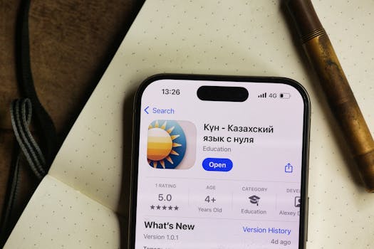 Smartphone displaying a Kazakh language learning app in a cozy setting.